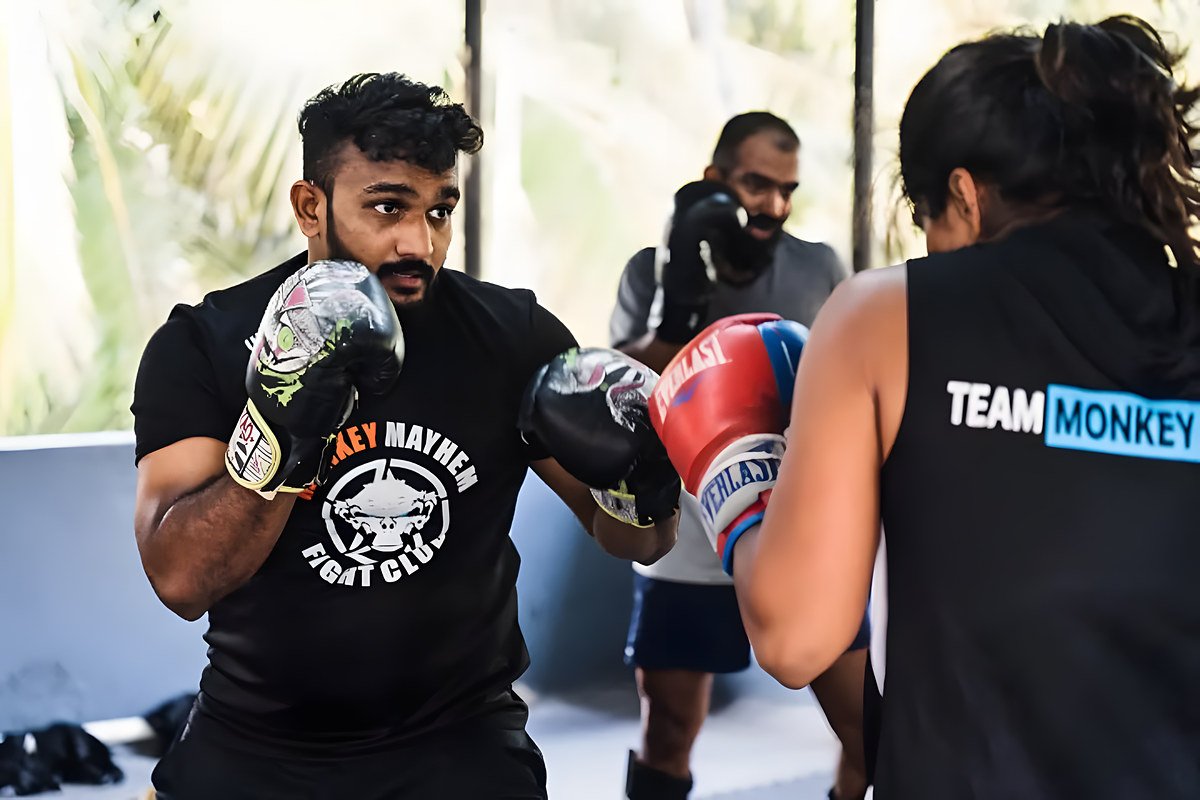 A fighter in a Monkey Mayhem t-shirt working with a partner in a Team Monkey vest