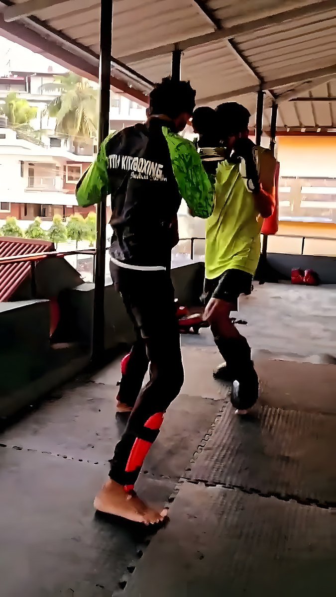 Two members doing kickboxing partner drills under the covered training area