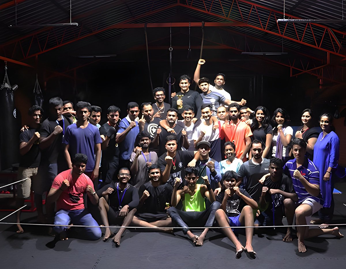 A large group of members posing in the ring at the gym