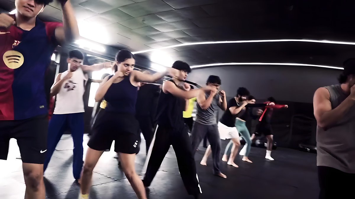 A large group throwing punches together across the gym floor