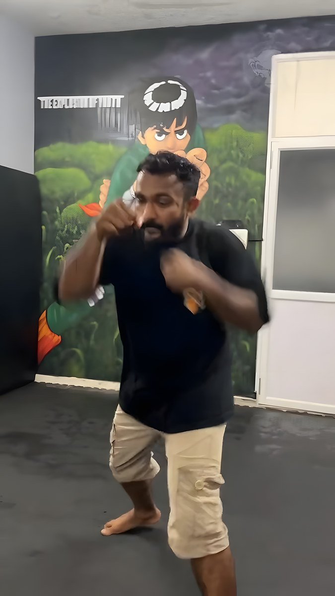 A member shadowboxing in front of a mural in the gym